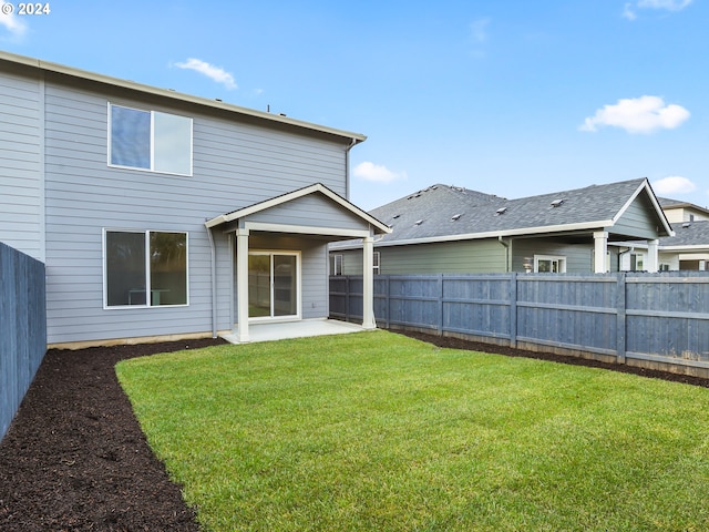 rear view of house featuring a yard