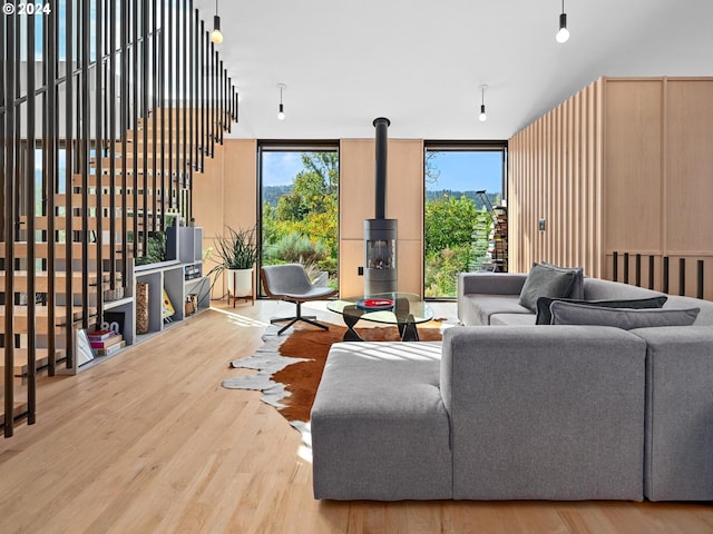 living room with a wood stove, hardwood / wood-style flooring, and expansive windows