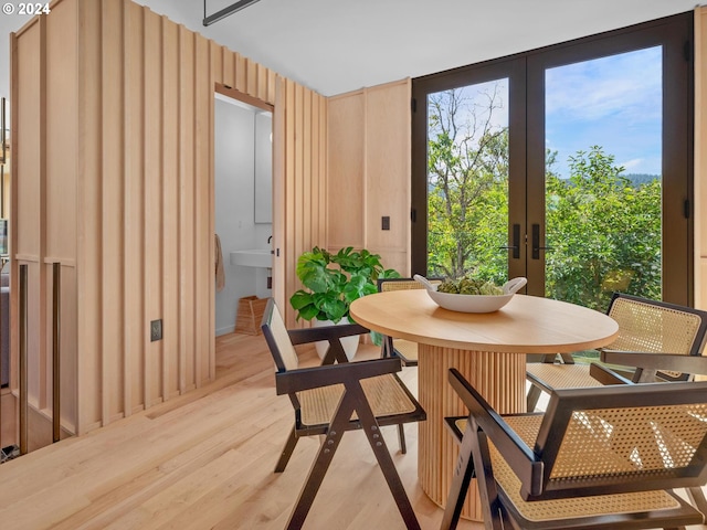 dining room with light wood-type flooring and french doors