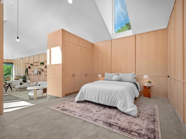 bedroom featuring wood walls and high vaulted ceiling