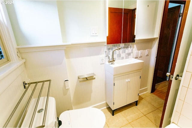 bathroom featuring tile patterned flooring, vanity, backsplash, and toilet