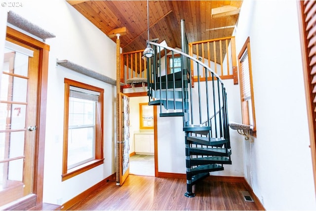 stairs with baseboards, visible vents, wooden ceiling, wood finished floors, and high vaulted ceiling