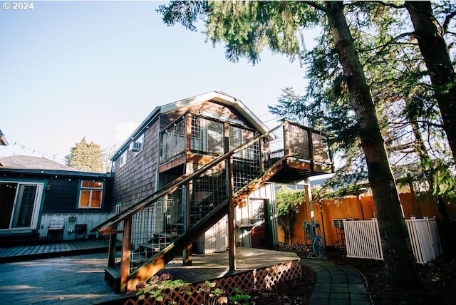 back of house with stairs, fence, and a wooden deck