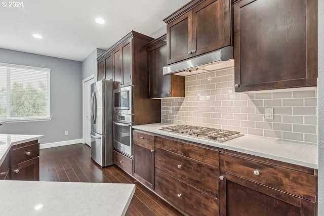 kitchen featuring dark brown cabinets, tasteful backsplash, appliances with stainless steel finishes, and dark hardwood / wood-style flooring