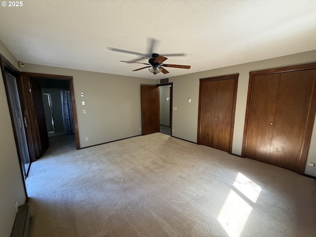 2822 S Tenmile Lk, Lakeside, OR 97449 - unfurnished bedroom with two closets, a textured ceiling, light colored carpet, and ceiling fan