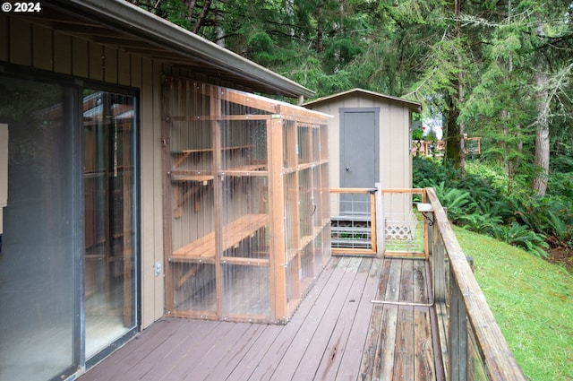 wooden deck featuring a shed and an outdoor structure