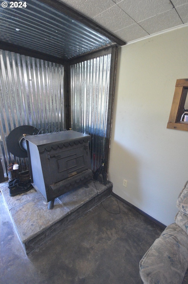 below grade area featuring a wood stove and baseboards