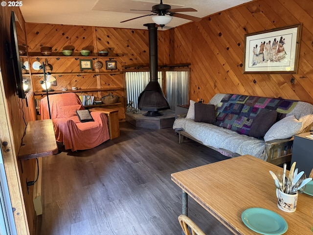 2822 S Tenmile Lk, Lakeside, OR 97449 - living room featuring wooden walls, wood finished floors, a wood stove, and a ceiling fan