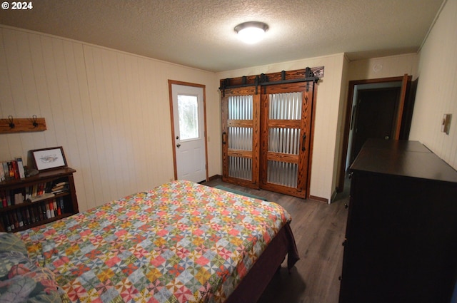 bedroom with a textured ceiling and wood finished floors