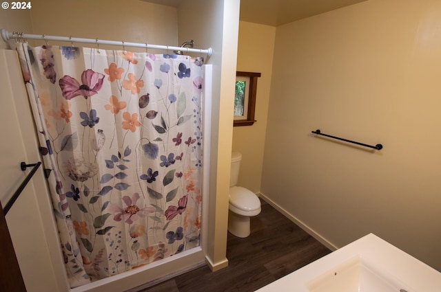 full bath with curtained shower, toilet, baseboards, and wood finished floors