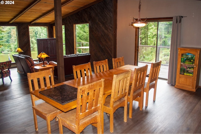 dining space with wooden walls, wood ceiling, wood finished floors, and vaulted ceiling with beams