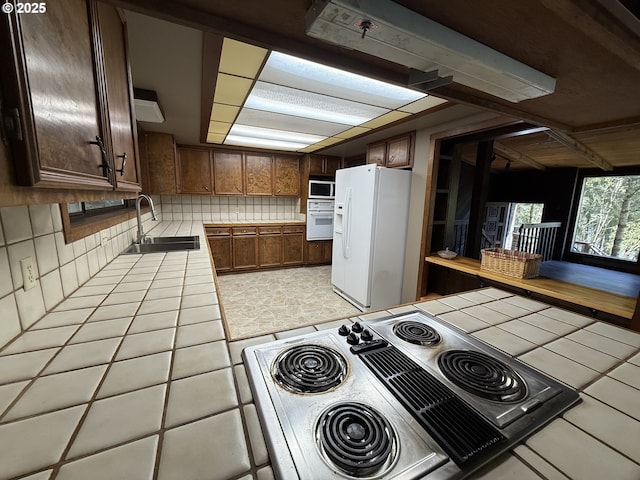 2822 S Tenmile Lk, Lakeside, OR 97449 - kitchen featuring tile countertops, light tile patterned floors, a sink, white appliances, and decorative backsplash