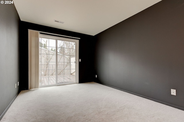 spare room featuring carpet and lofted ceiling