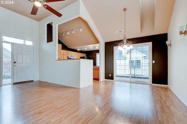 interior space with light hardwood / wood-style flooring, ceiling fan with notable chandelier, track lighting, and high vaulted ceiling