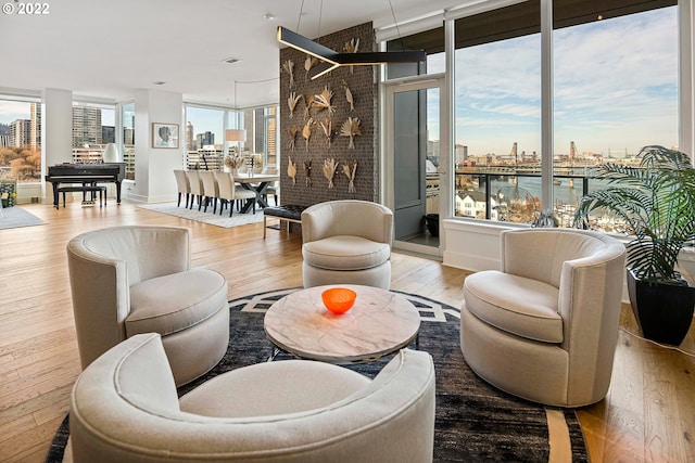 interior space featuring light wood-type flooring, floor to ceiling windows, and a water view