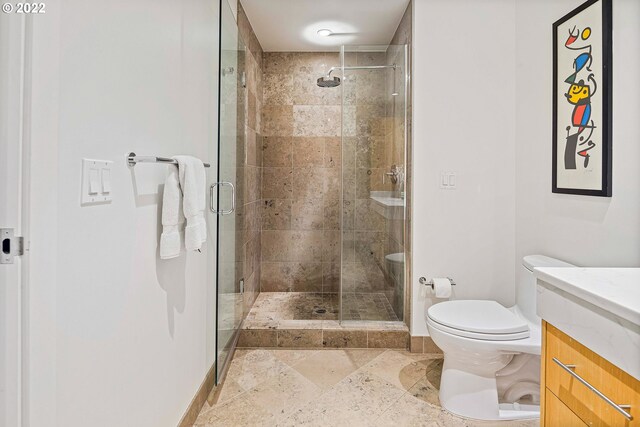 bathroom with an enclosed shower, vanity, toilet, and tile patterned flooring