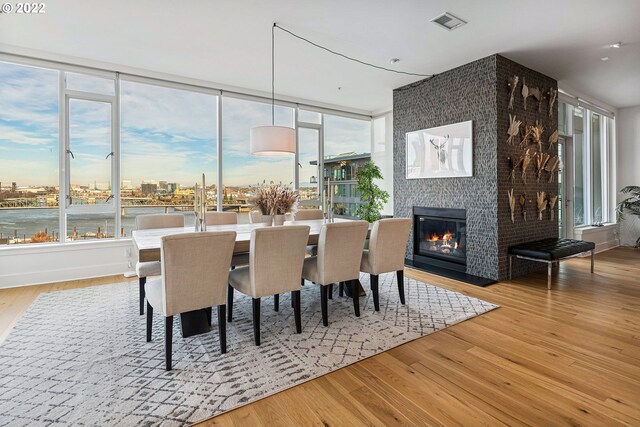 dining area with light wood-type flooring and a fireplace