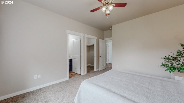 carpeted bedroom featuring ceiling fan, a closet, connected bathroom, and a spacious closet