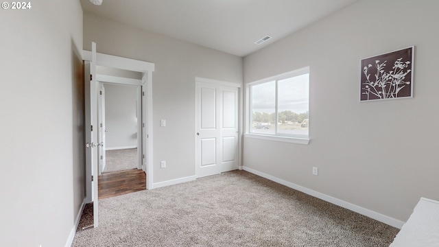 unfurnished bedroom with carpet floors and a closet