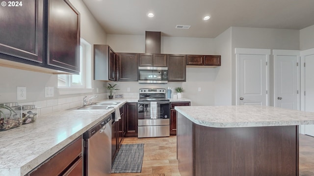 kitchen with a kitchen island, sink, light hardwood / wood-style floors, appliances with stainless steel finishes, and dark brown cabinets