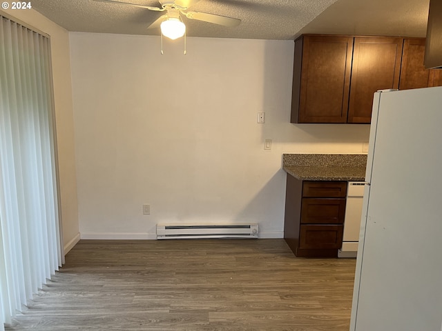 kitchen featuring a textured ceiling, white appliances, light hardwood / wood-style flooring, and baseboard heating