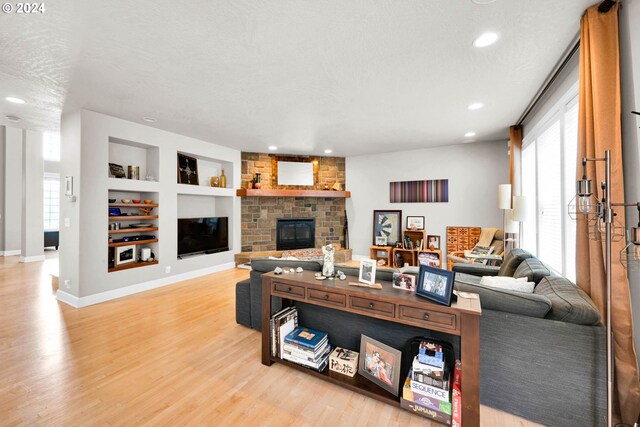 living room with a fireplace, plenty of natural light, and wood-type flooring