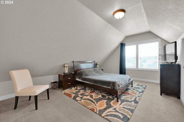 bedroom featuring a textured ceiling, light carpet, and vaulted ceiling