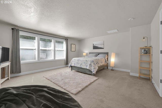 bedroom featuring light carpet and a textured ceiling