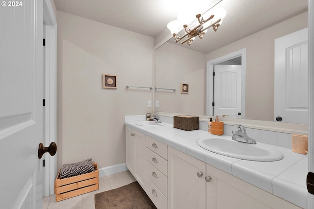 bathroom featuring a textured ceiling, vanity, and tile patterned floors