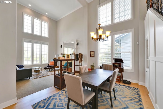 dining area with plenty of natural light, crown molding, and light hardwood / wood-style flooring