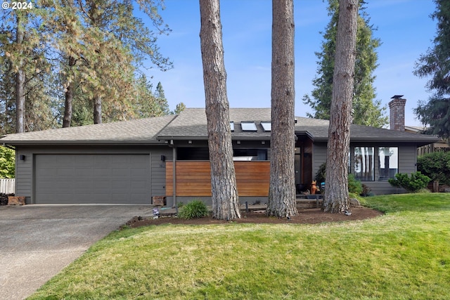 ranch-style home featuring a garage and a front lawn