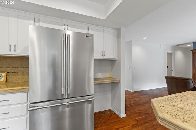 kitchen with high end fridge, dark wood-type flooring, backsplash, and white cabinets