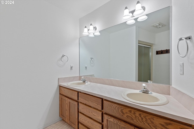 bathroom featuring tile patterned flooring, an enclosed shower, and vanity