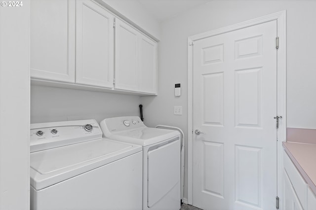 laundry area with washing machine and clothes dryer and cabinets