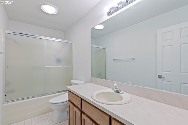 full bathroom with shower / bath combination with glass door, vanity, tile patterned flooring, and toilet