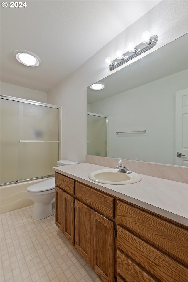 full bathroom featuring shower / bath combination with glass door, vanity, and toilet