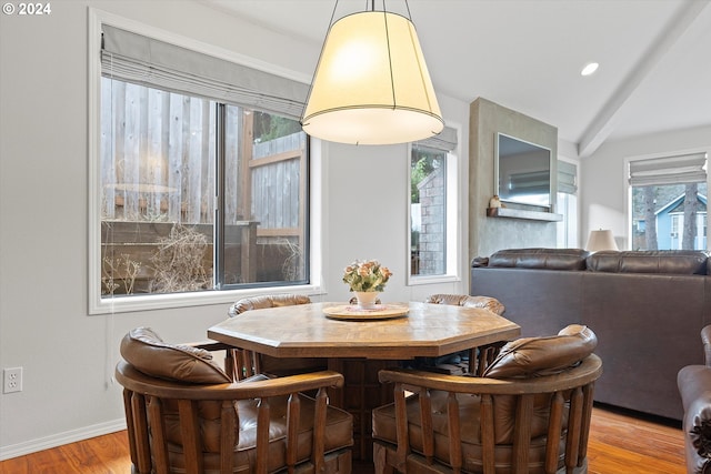 dining area featuring vaulted ceiling and light hardwood / wood-style flooring