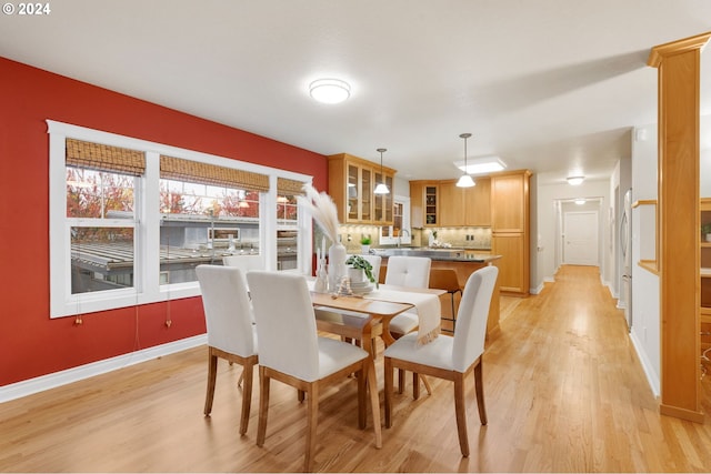 dining space with sink and light hardwood / wood-style floors