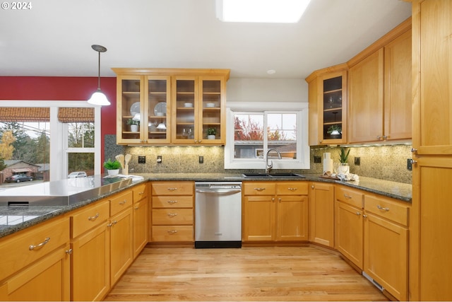 kitchen featuring stainless steel dishwasher, light wood-type flooring, sink, and a wealth of natural light