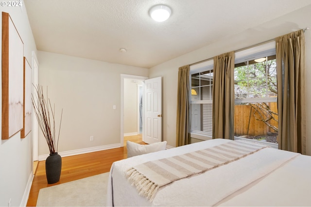 bedroom with hardwood / wood-style floors and a textured ceiling