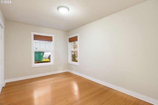 unfurnished room featuring a textured ceiling and hardwood / wood-style flooring