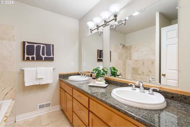 bathroom with a washtub, vanity, and tile patterned flooring