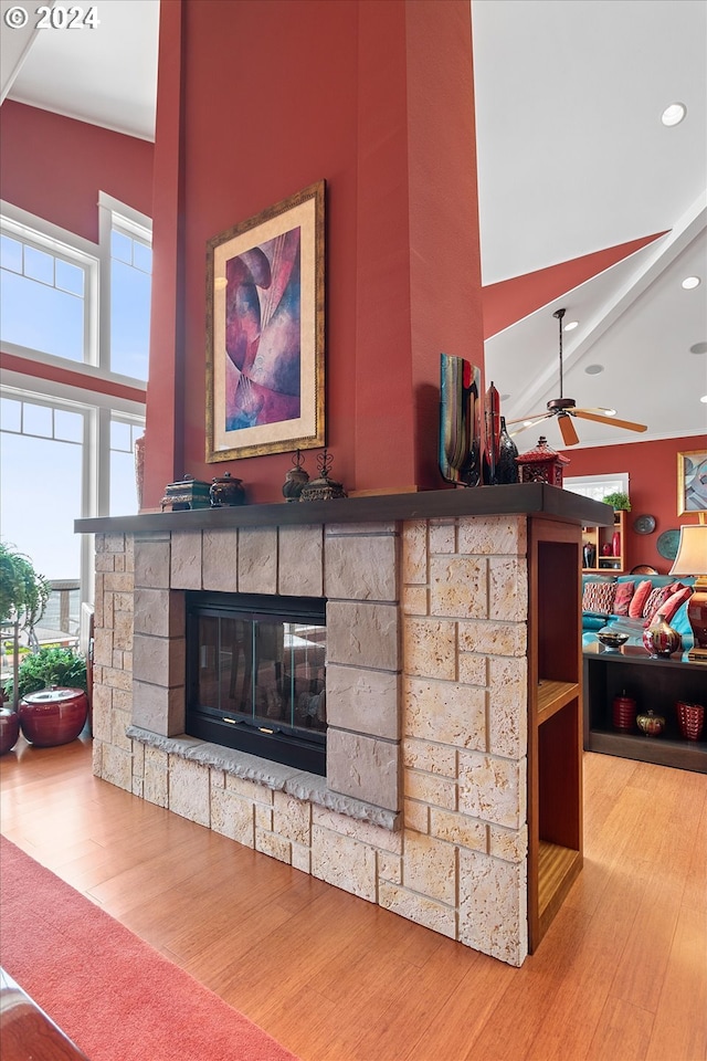 interior details featuring a ceiling fan, recessed lighting, a stone fireplace, and wood finished floors