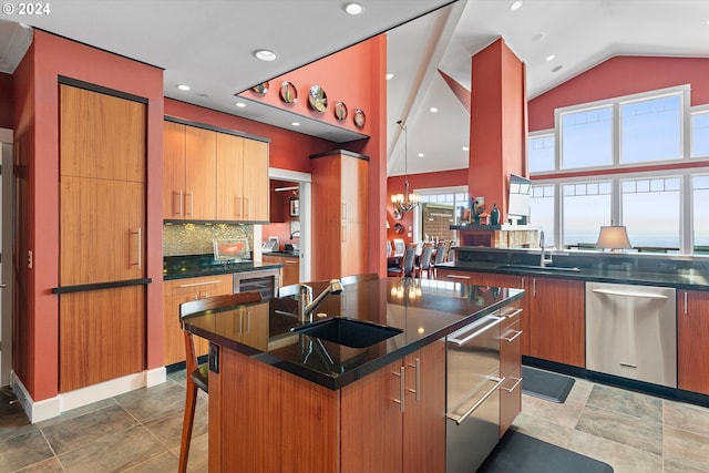 kitchen featuring a sink, dishwasher, a center island with sink, and dark countertops