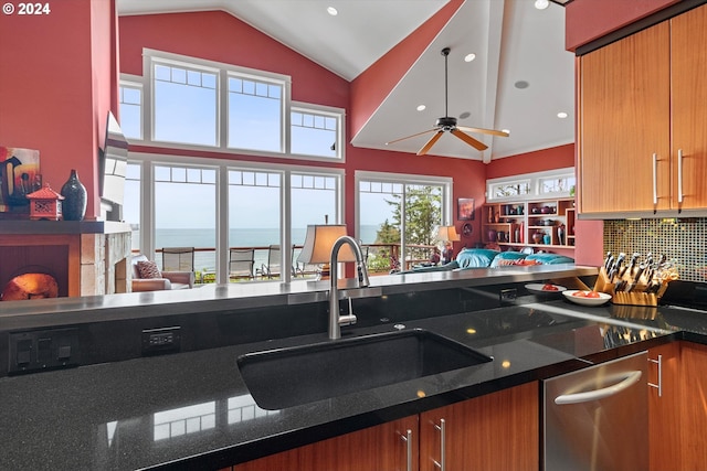 kitchen with ceiling fan, tasteful backsplash, brown cabinets, a sink, and lofted ceiling