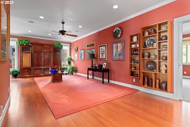 living area with ceiling fan, recessed lighting, baseboards, light wood-type flooring, and ornamental molding