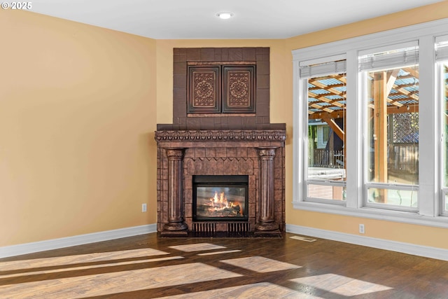 unfurnished living room featuring plenty of natural light and dark wood-type flooring