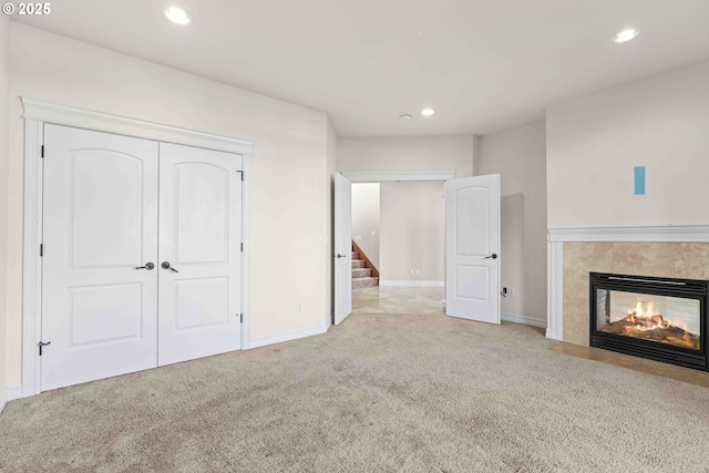 unfurnished living room with a multi sided fireplace and light colored carpet