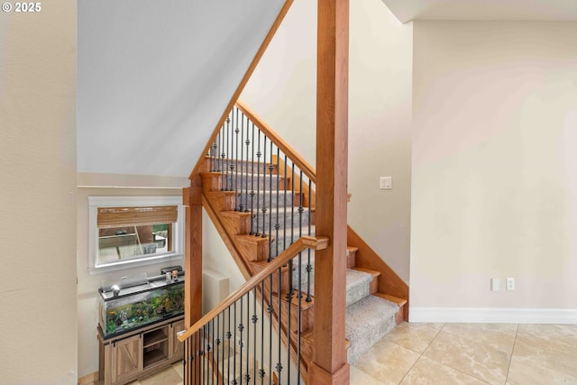 staircase with tile patterned floors and lofted ceiling