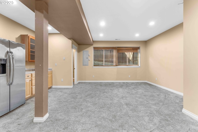 unfurnished living room with electric panel and light colored carpet